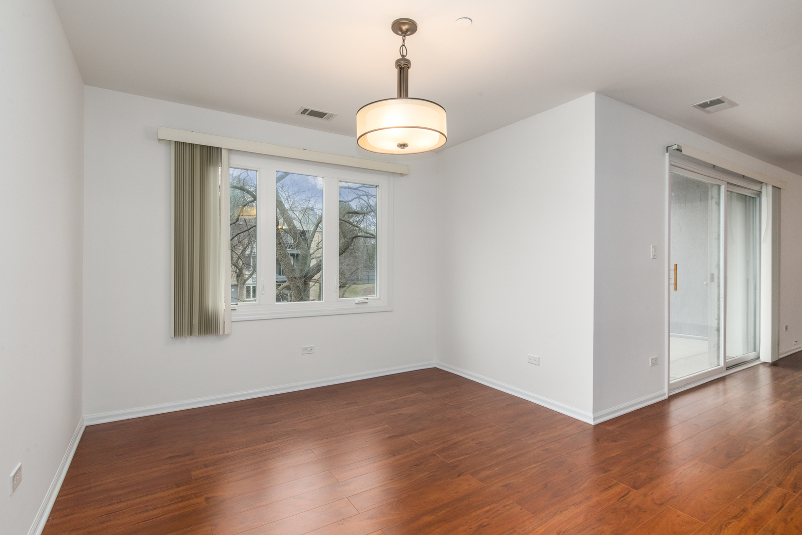 2021 Ammer Ridge Court, Unit 202 Glenview, IL 60025 - Photo 9 of 24 an empty room with wooden floor and windows