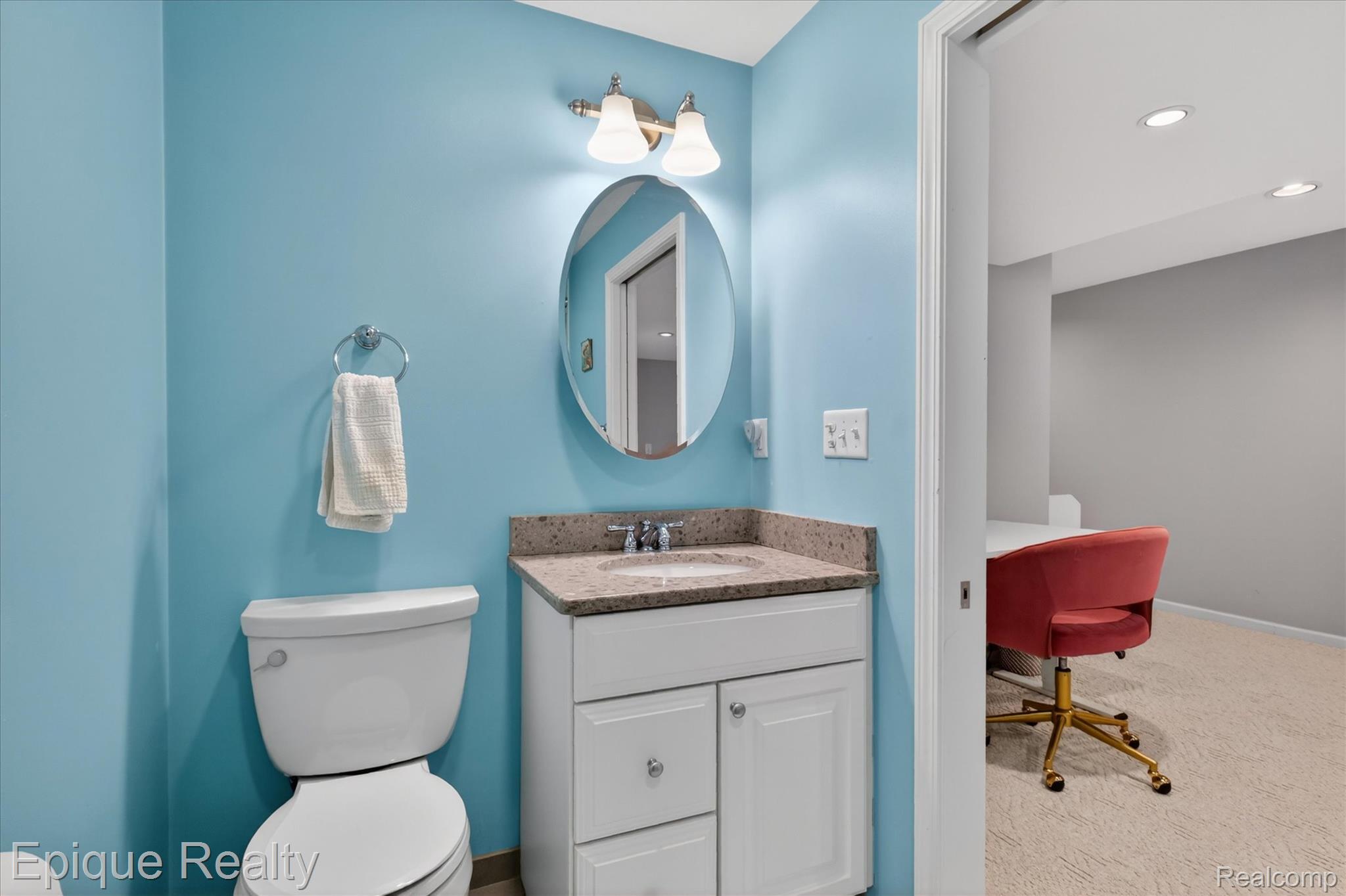 760 Caribou Court Rochester, MI 48307 - Photo 43 of 67 Bathroom featuring a white vanity with ample storage, a speckled countertop, an oval mirror, and a two-light fixture