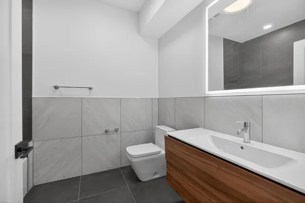 a bathroom with a toilet sink and mirror