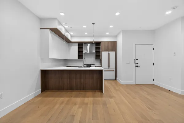a view of kitchen with granite countertop cabinets and refrigerator