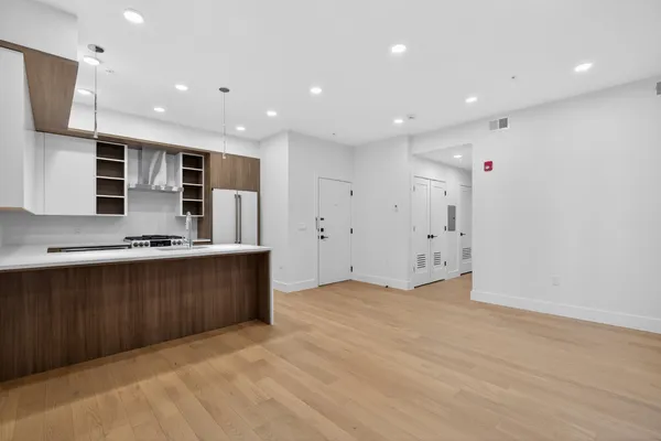 a view of kitchen with stainless steel appliances refrigerator sink and cabinets