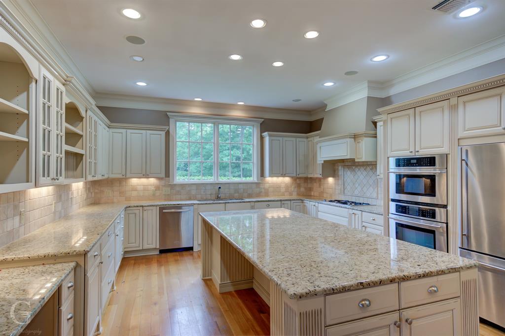 1212 WPA Road Homer, LA 71040 - Photo 27 of 35 Kitchen featuring stainless steel appliances, a sink, a kitchen island, ornamental molding, and light stone countertops