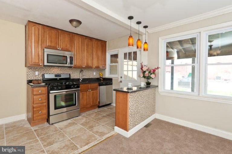 47 Hawthorne Road Middle River, MD 21220 - Photo 4 of 19 a kitchen with stainless steel appliances granite countertop a stove top oven a sink a microwave and a refrigerator
