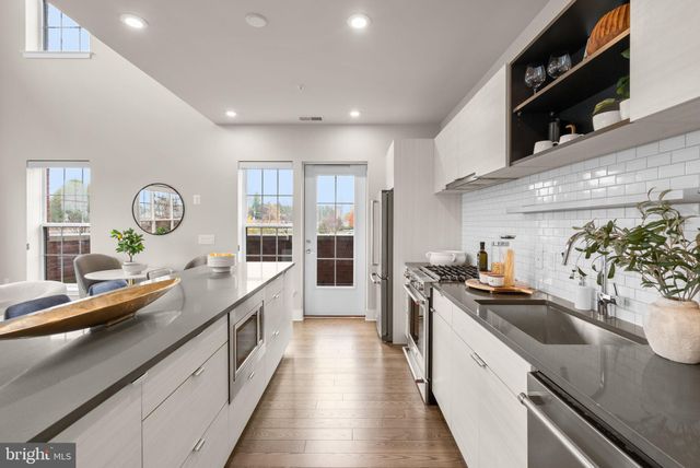 a large kitchen with stainless steel appliances granite countertop a lot of counter space and wooden floors