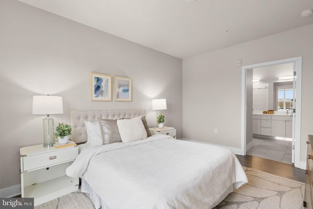 a bedroom with a bed and a lamp on a dresser