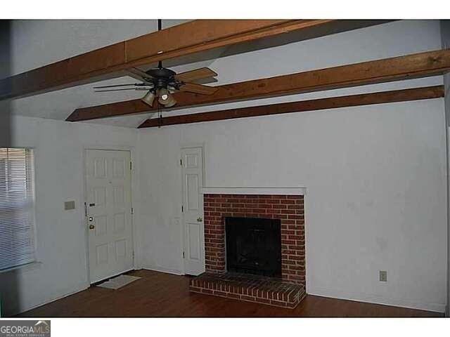 771 Farm Creek Road Northeast Woodstock, GA 30188 - Photo 11 of 14 a view of a livingroom with a fireplace a chandelier fan and wooden floor