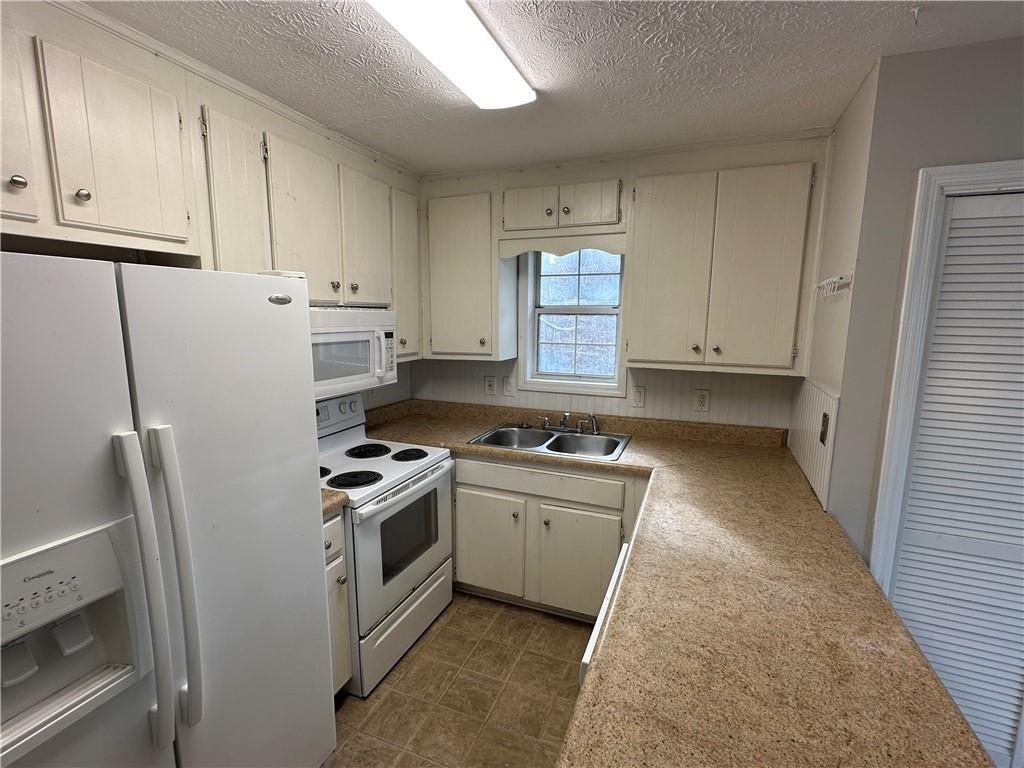 771 Farm Creek Road Northeast Woodstock, GA 30188 - Photo 6 of 14 a kitchen with a stove oven and white cabinets