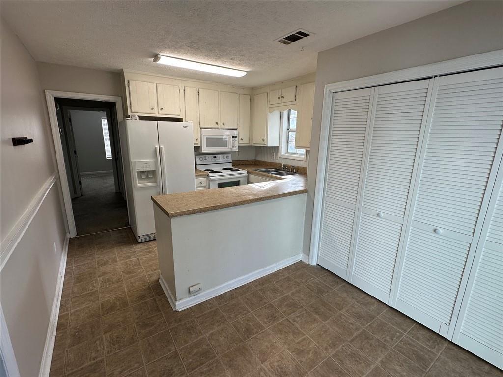 771 Farm Creek Road Northeast Woodstock, GA 30188 - Photo 7 of 14 a kitchen with stainless steel appliances a refrigerator and a stove top oven