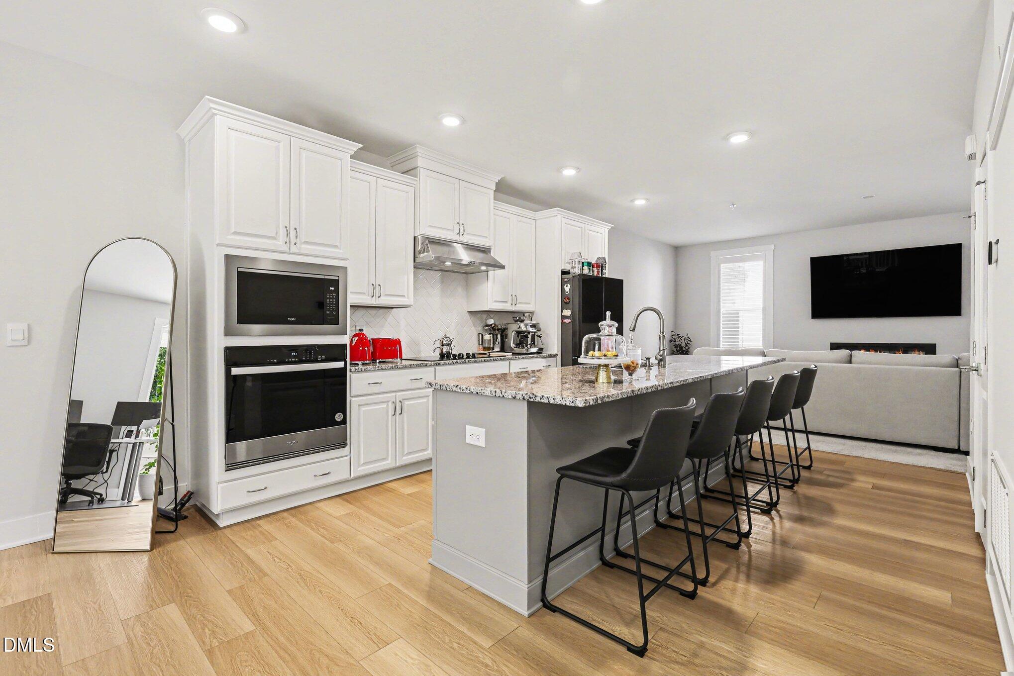 11549 Helmond Way, Unit 115 Raleigh, NC 27617 - Photo 6 of 25 a kitchen with stainless steel appliances a stove a sink and a microwave