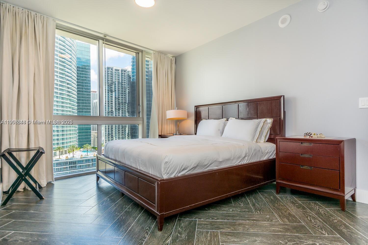485 Brickell Avenue, Unit 2302 Miami, FL 33131 - Photo 16 of 20 a bed sitting in a bedroom next to a window