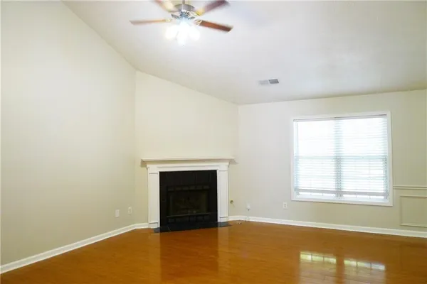 an empty room with windows and fireplace