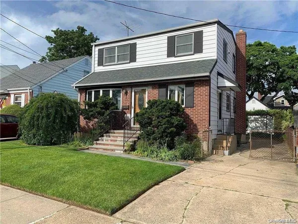 a front view of a house with a yard and potted plants