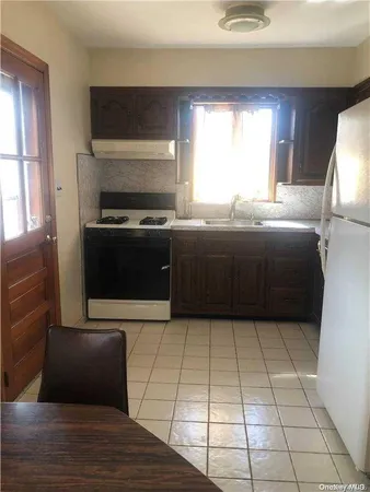a kitchen with a stove a sink and a window