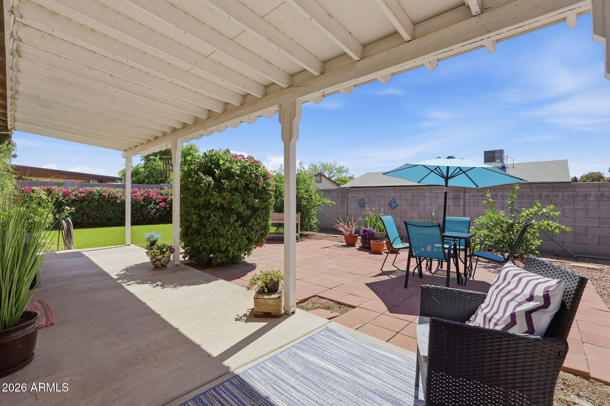 3765 East Pershing Avenue Phoenix, AZ 85032 - Photo 31 of 48 a view of a patio with couches table and chairs under an umbrella