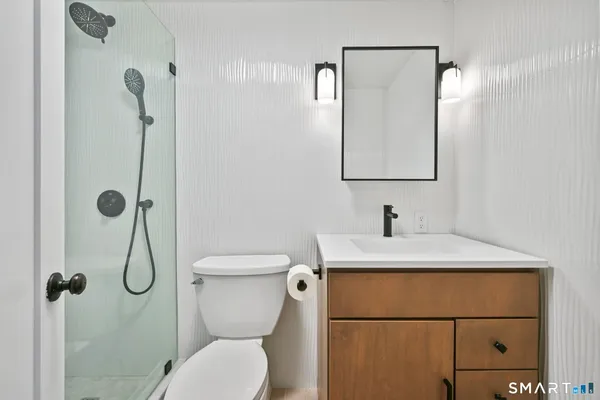a bathroom with a toilet sink vanity and mirror