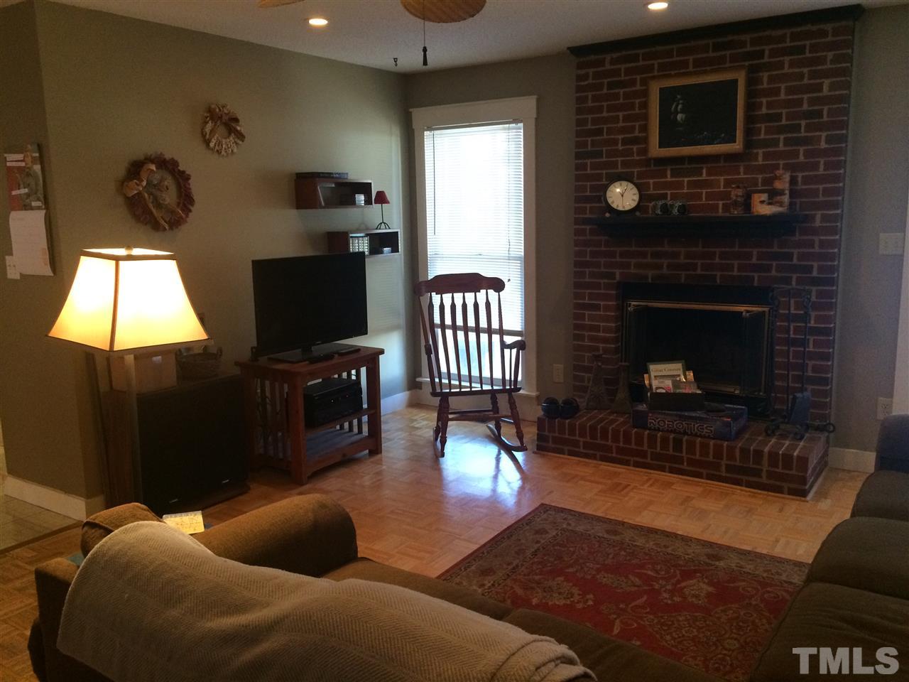 3525 Castlegate Drive Raleigh, NC 27616 - Photo 3 of 5 a living room with furniture a flat screen tv and a fireplace