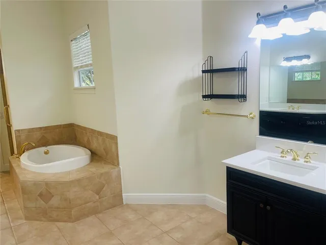 a spacious bathroom with a double vanity sink a mirror and a bathtub
