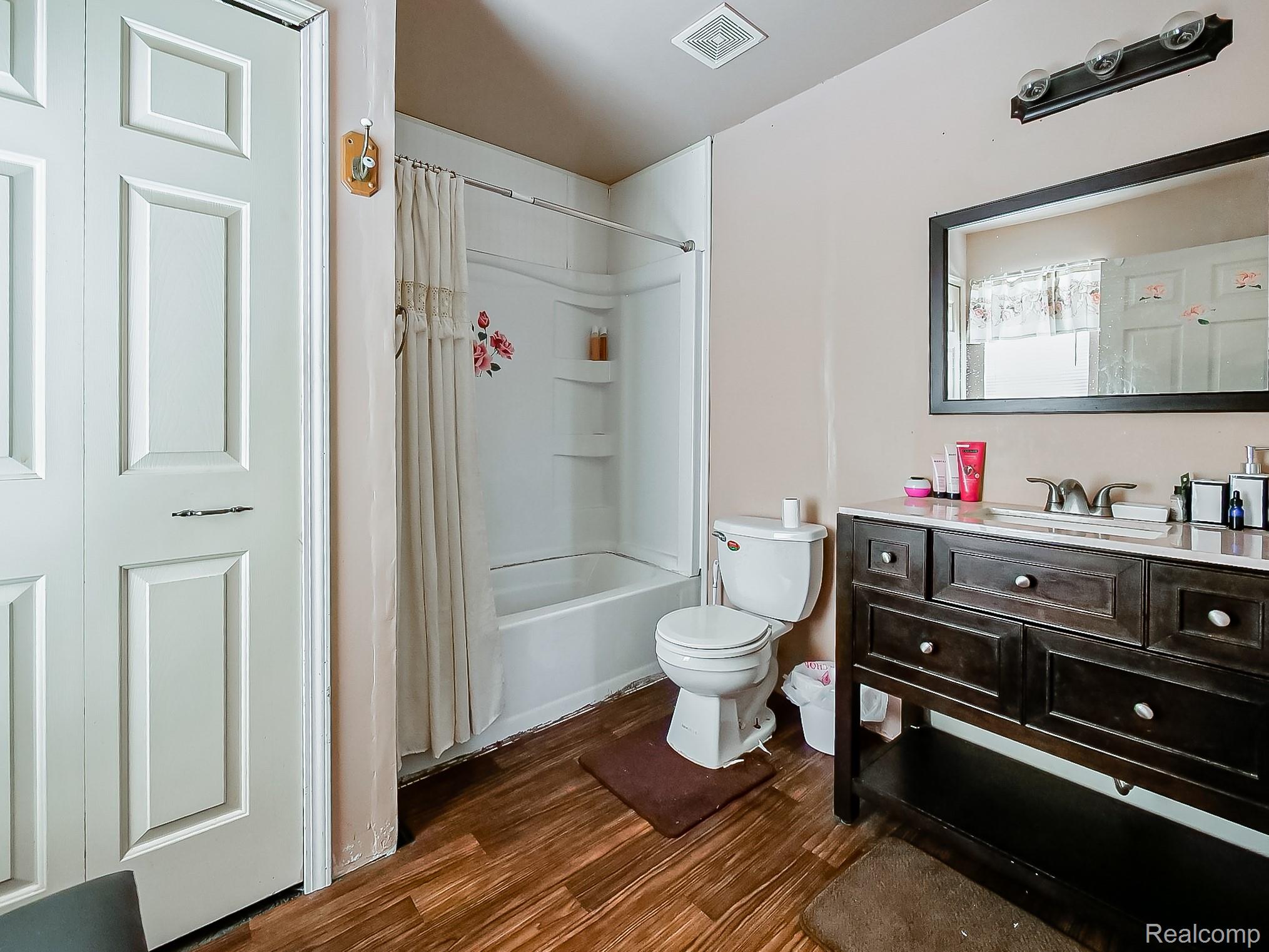 34460 Van Born Road Wayne, MI 48184 - Photo 16 of 31 Bathroom featuring shower / bathtub combination with curtain, vanity, and dark wood-style floors