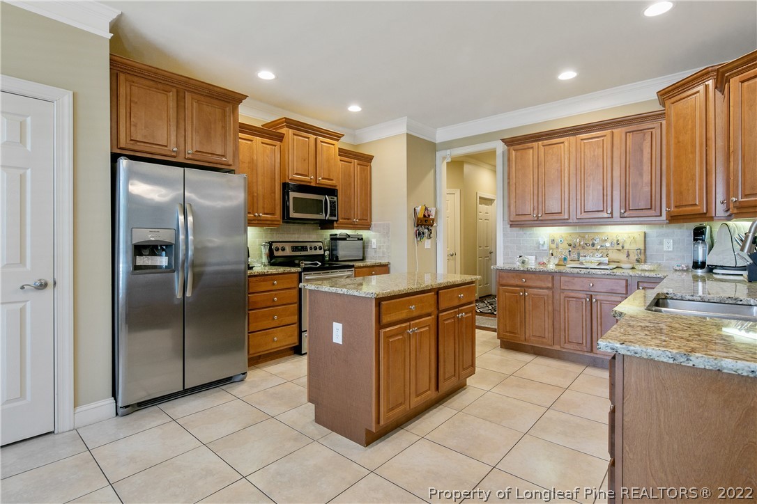 489 Falling Water Road Spring Lake, NC 28390 - Photo 21 of 50 a kitchen with stainless steel appliances granite countertop a stove a refrigerator and a sink