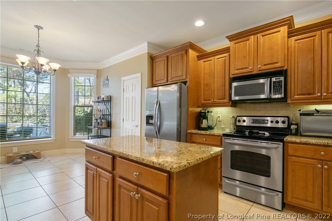 489 Falling Water Road Spring Lake, NC 28390 - Photo 26 of 50 a kitchen with stainless steel appliances granite countertop a stove refrigerator and microwave