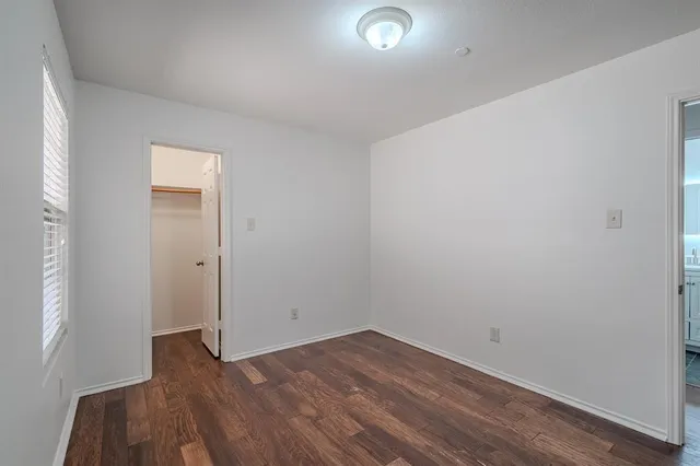 an empty room with wooden floor and closet