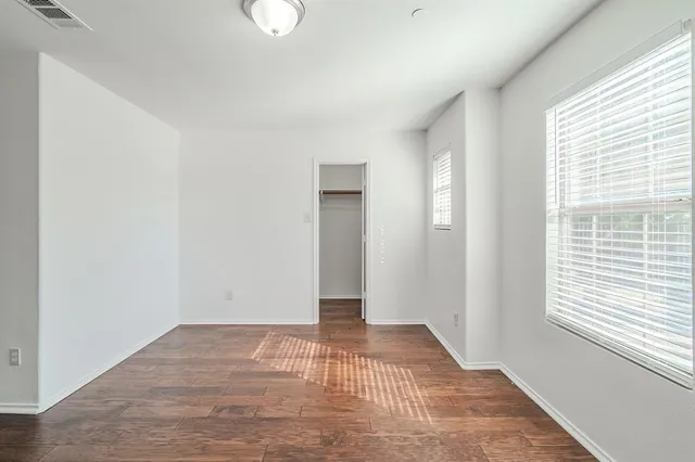 a view of a room with wooden floor and windows