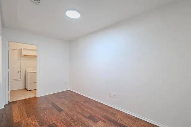 a view of empty room with wooden floor and space