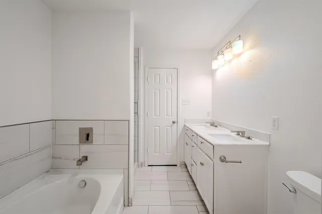 a bathroom with a tub sink and mirror