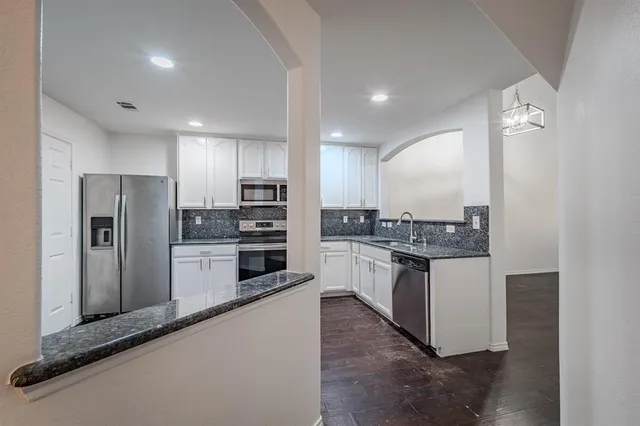 a kitchen with stainless steel appliances granite countertop a refrigerator and a sink