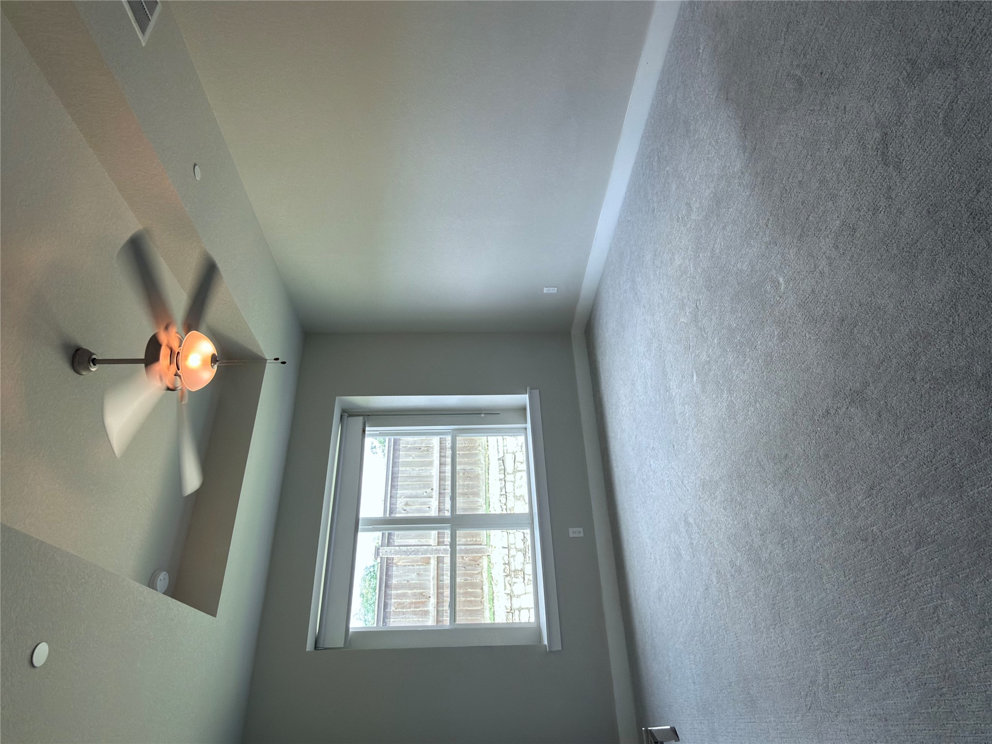 11216 Gadsen Lane Austin, TX 78754 - Photo 15 of 36 A spacious, naturally illuminated room boasts soft carpeting and a distinctive tray ceiling with a modern fan.