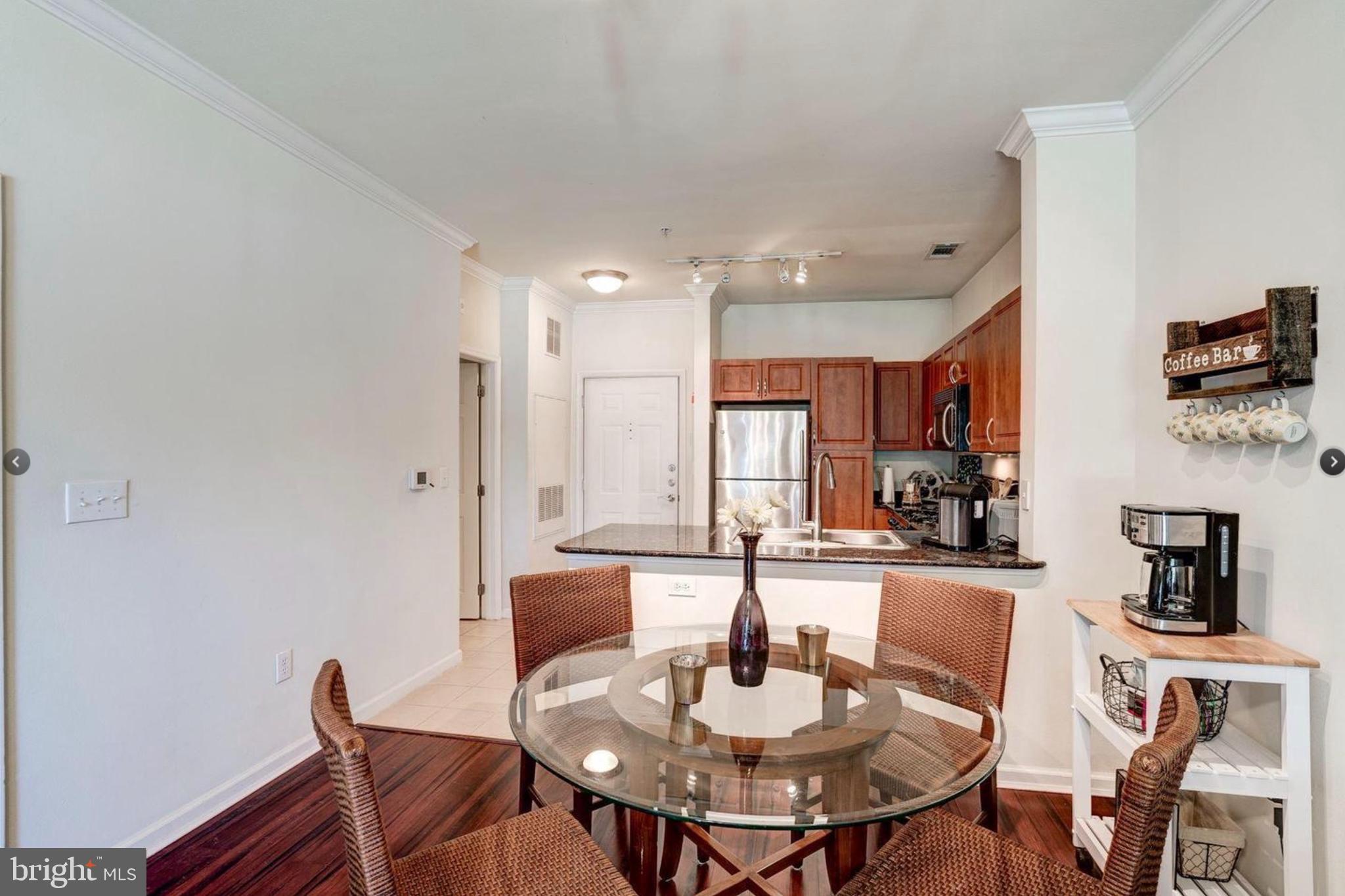 12957 Centre Park Circle, Unit 112 Herndon, VA 20171 - Photo 5 of 25 a dining room with furniture and a kitchen view