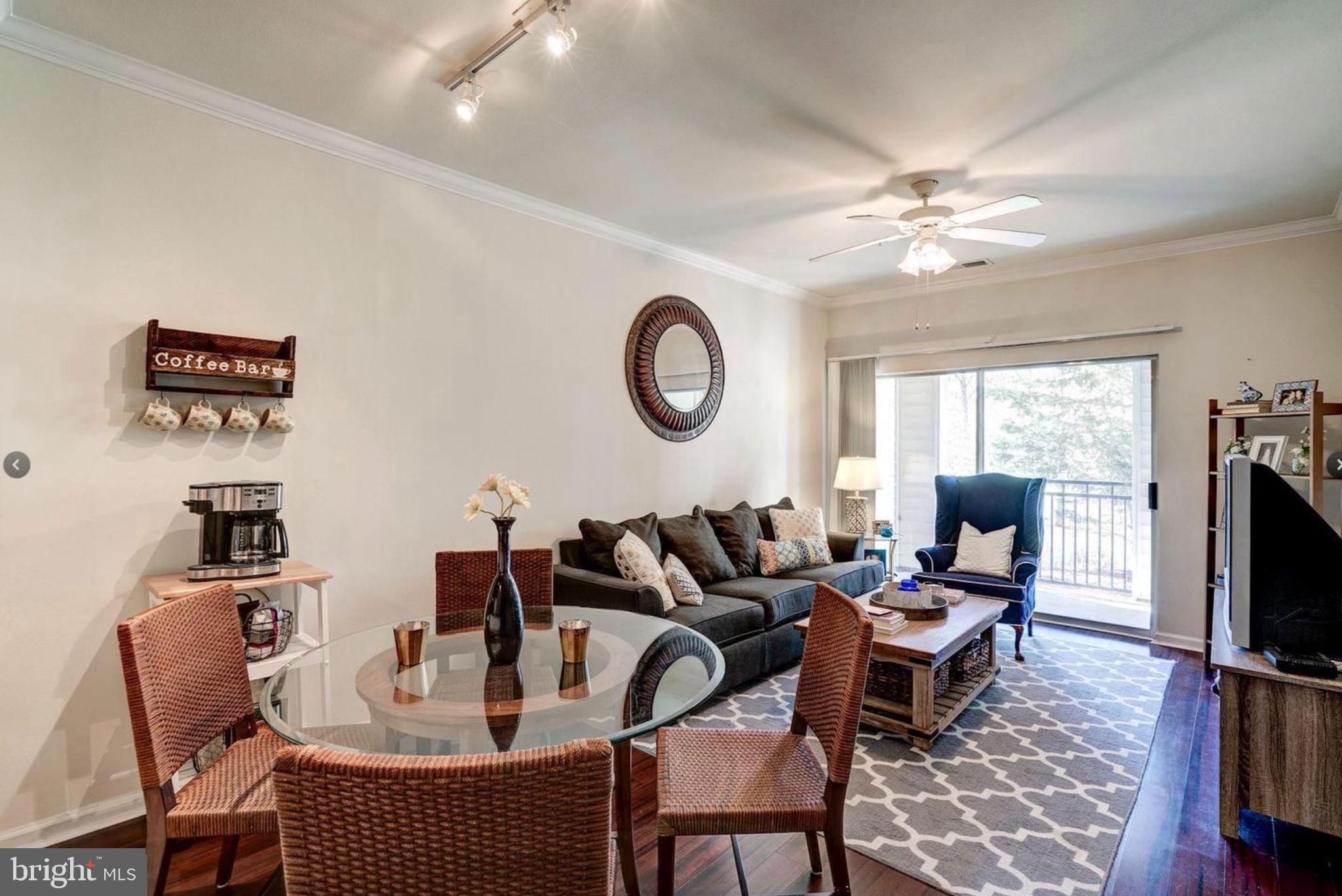 12957 Centre Park Circle, Unit 112 Herndon, VA 20171 - Photo 7 of 25 a living room with furniture a flat screen tv and a window