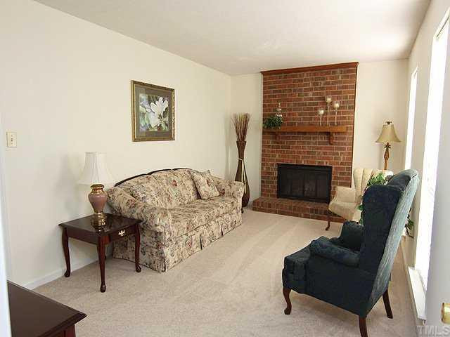 715 Rippling Stream Road Durham, NC 27704 - Photo 2 of 12 Bright living room features sunny windows, wood-burning fireplace and brand new carpeting. Living Room