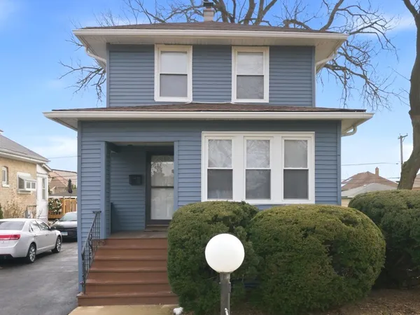 a view of a house with a large window and potted plants