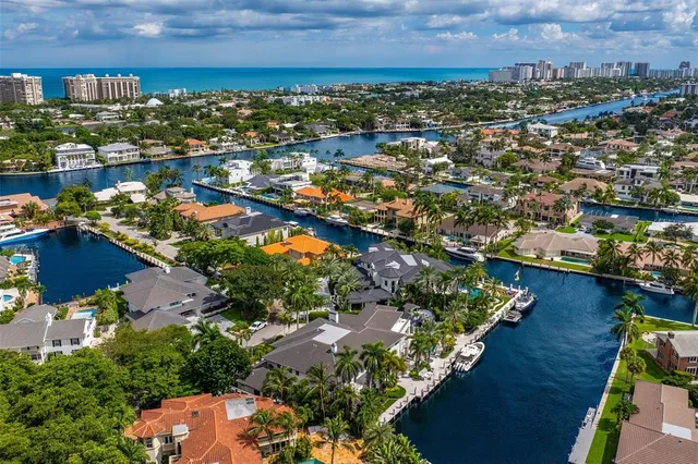 an aerial view of a city with lots of residential buildings ocean and mountain view in back
