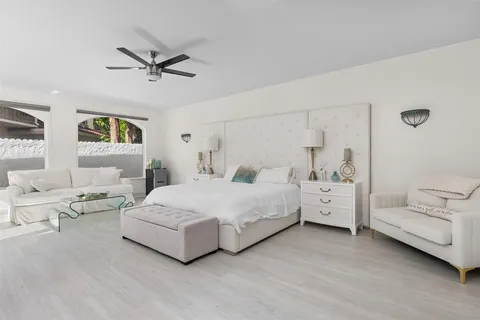 a view of a house with a yard and palm trees