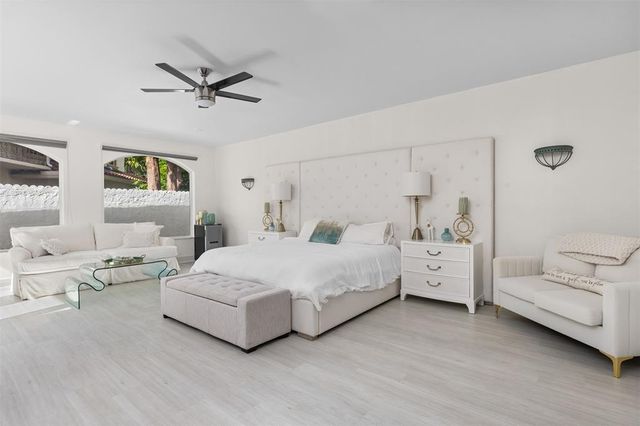 a view of a house with a yard and palm trees