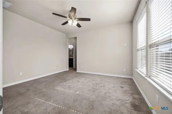 an empty room with a window and a fan