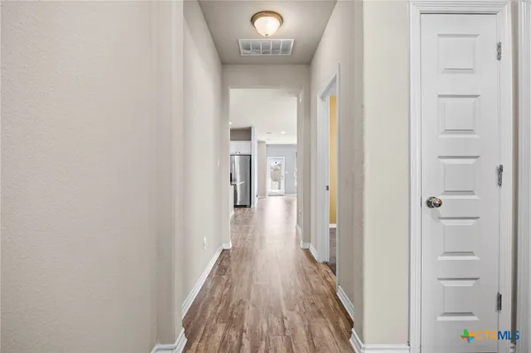 a view of a hallway with wooden floor