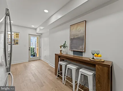 a view of a hallway with wooden floor and furniture