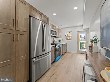 a kitchen with stainless steel appliances a refrigerator and wooden floor