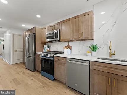 a kitchen with white cabinets stainless steel appliances and a sink