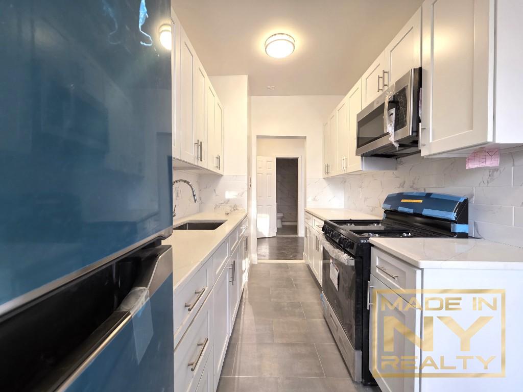 a kitchen with stainless steel appliances a sink stove top oven and cabinets