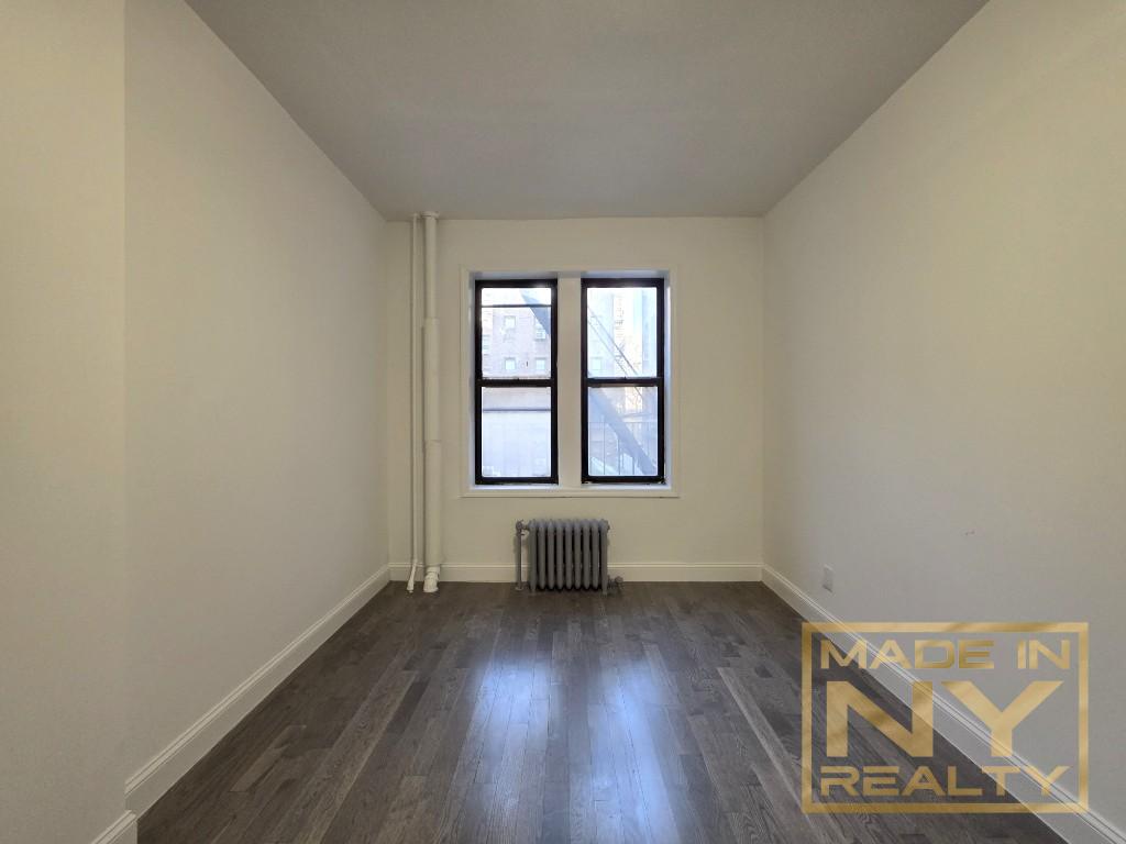117-14 Union Turnpike, Unit EB2 Queens, NY 11415 - Photo 6 of 10 an empty room with wooden floor and windows
