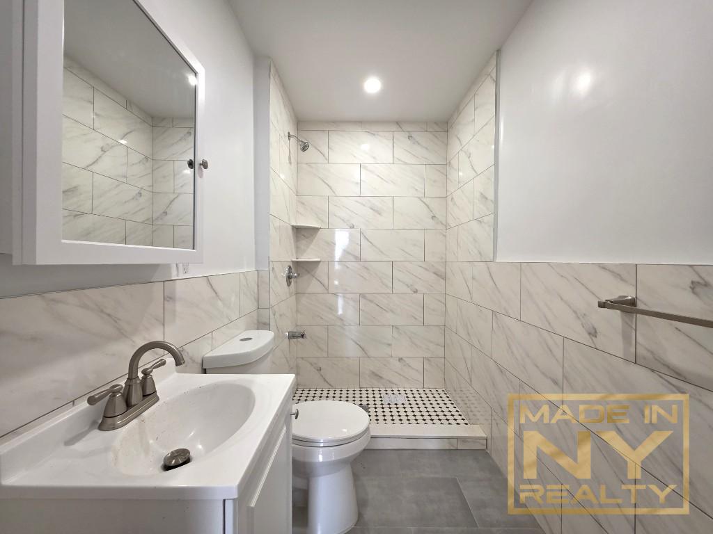 117-14 Union Turnpike, Unit EB2 Queens, NY 11415 - Photo 8 of 10 a bathroom with a sink toilet and shower