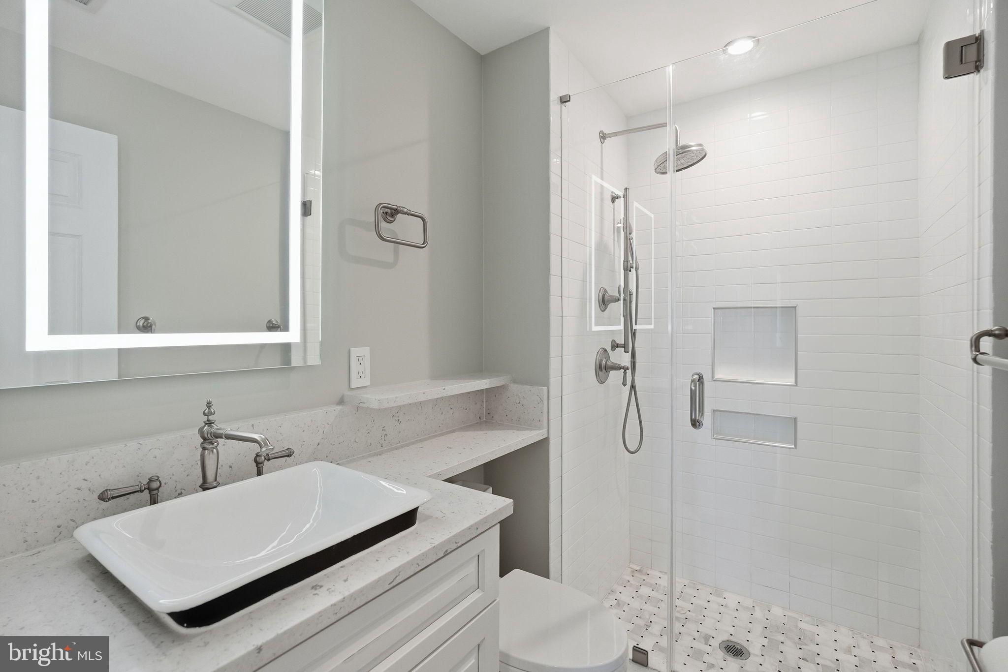 1140 23rd Street Northwest, Unit 1005 Washington, DC 20037 - Photo 15 of 22 a bathroom with a sink a toilet and shower