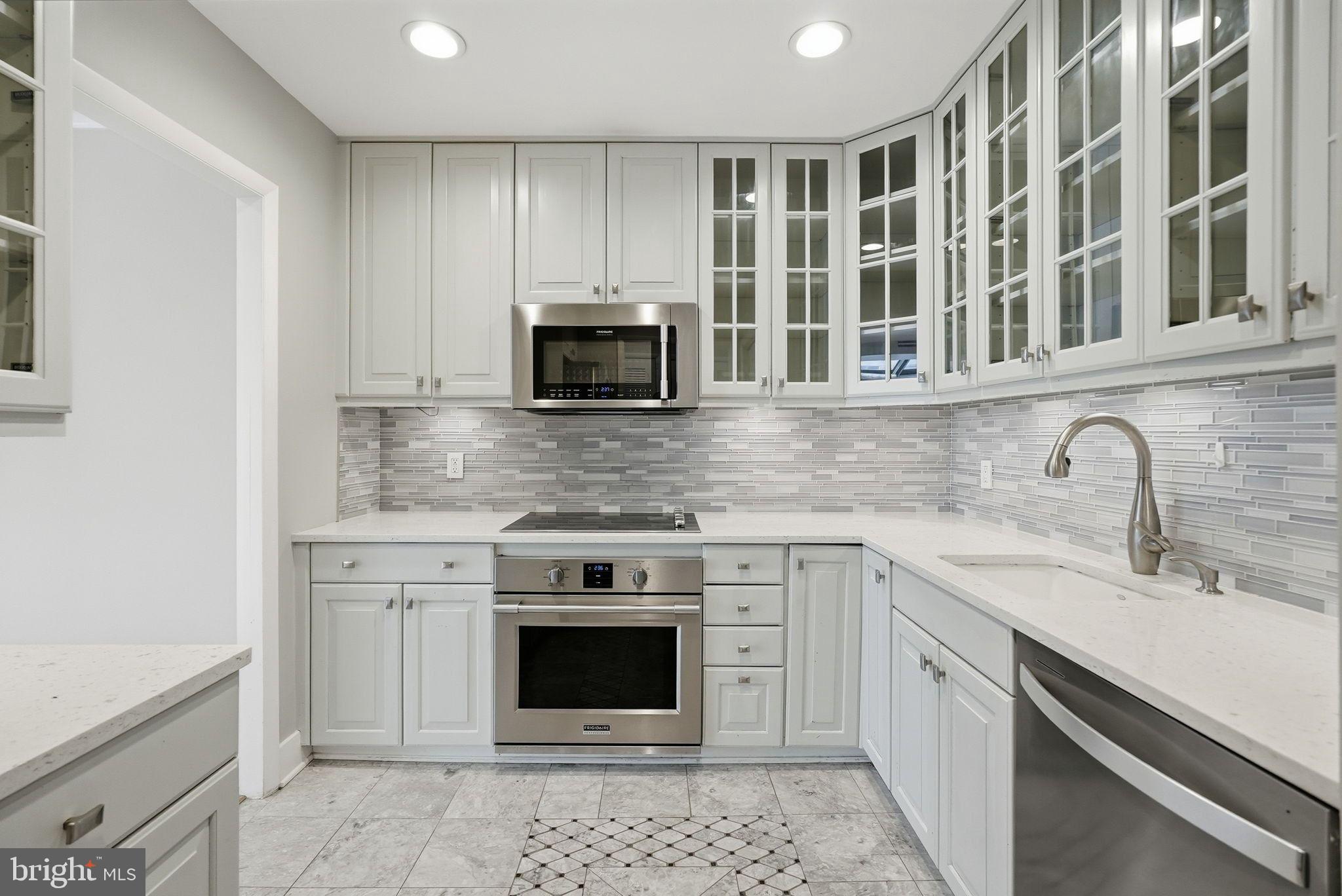 1140 23rd Street Northwest, Unit 1005 Washington, DC 20037 - Photo 4 of 22 a kitchen with stainless steel appliances granite countertop a stove a sink and a microwave