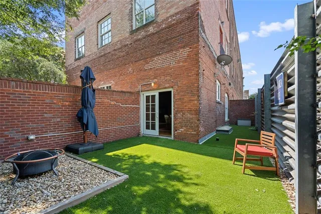 a view of a backyard with table and chairs potted plants and a fire pit
