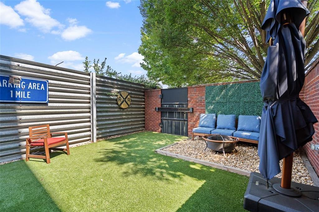 490 Marietta Street Northwest, Unit 101 Atlanta, GA 30313 - Photo 54 of 102 a backyard of a house with barbeque oven table and chairs