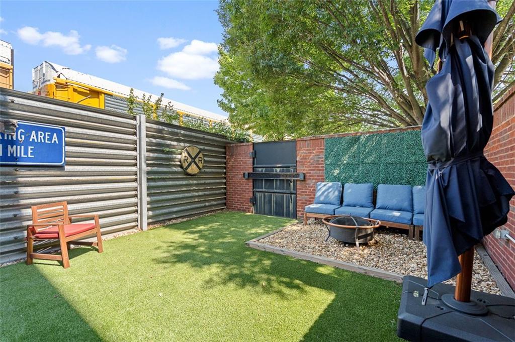 490 Marietta Street Northwest, Unit 101 Atlanta, GA 30313 - Photo 56 of 102 a backyard of a house with barbeque oven table and chairs